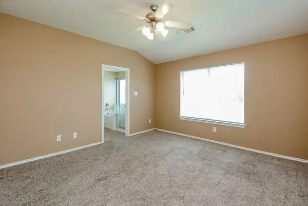 an empty room with a window and a ceiling fan