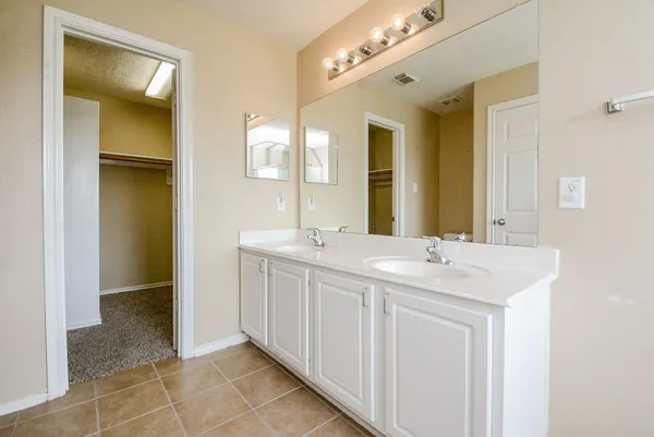 a spacious bathroom with a double vanity sink and a mirror