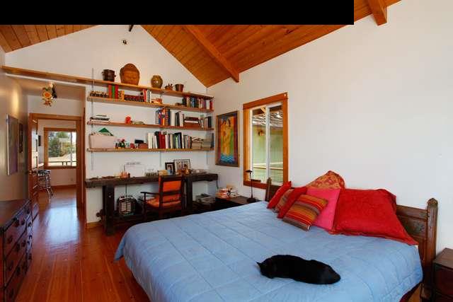 429 Omaopio Road Kula, HI 96790 - Photo 18 of 27 a bedroom with a bed and a dresser with wooden floor