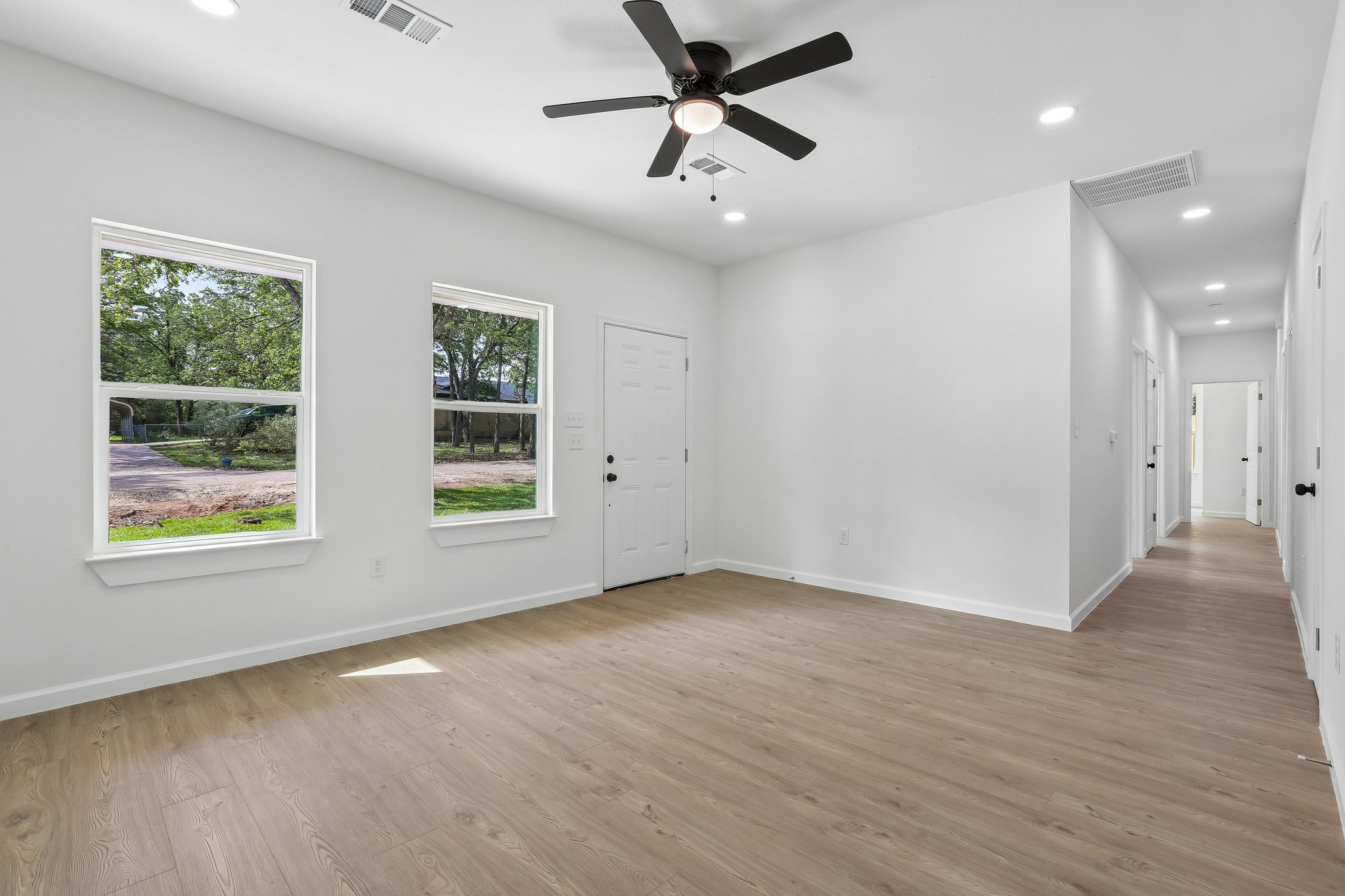 210 Flint Ridge Street Bastrop, TX 78602 - Photo 7 of 40 a view of an empty room with a window and wooden floor