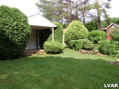 Back of house featuring covered rear porch off of 2 car garage.