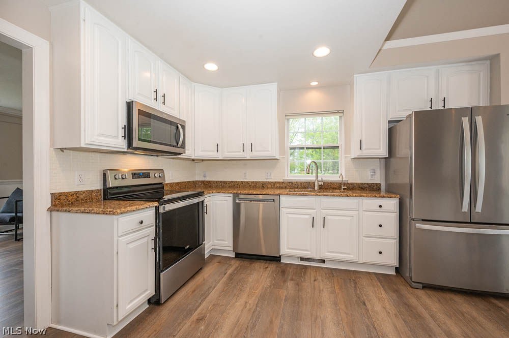 6787 South Palmyra Road Canfield, OH 44406 - Photo 7 of 30 Kitchen featuring white cabinetry, stone countertops, stainless steel appliances, wood-finish flooring, and recessed lighting