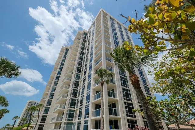 a front view of a building with a garden and plants