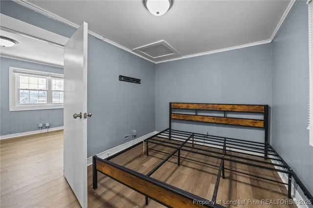 a view of empty room with wooden floor and window