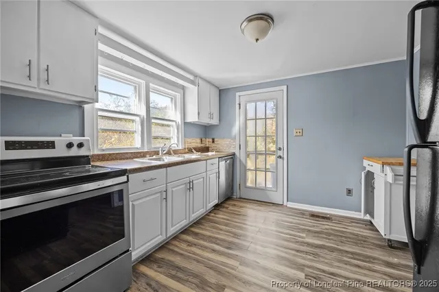 a view of a kitchen with wooden floor and cabinets