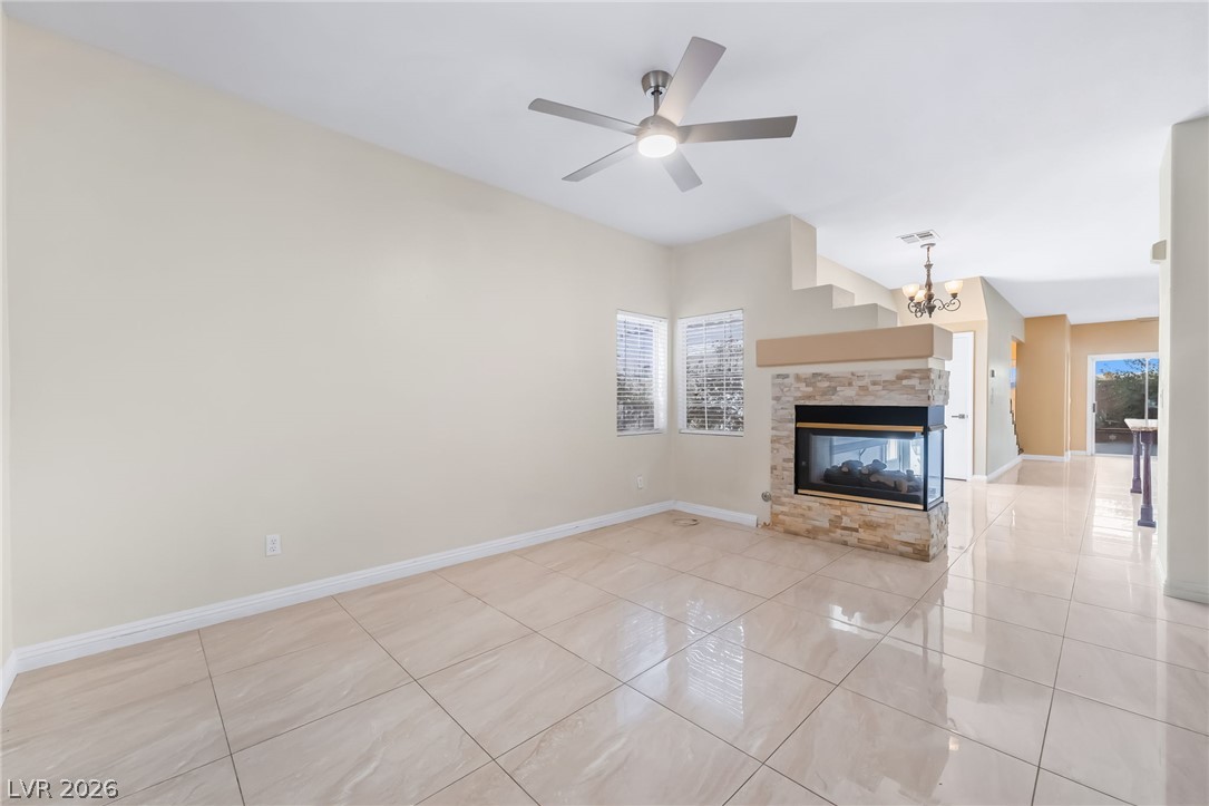 5905 Crumbling Ridge Street Henderson, NV 89011 - Photo 4 of 28 Gleaming tile floors and a stone fireplace define this open living space.