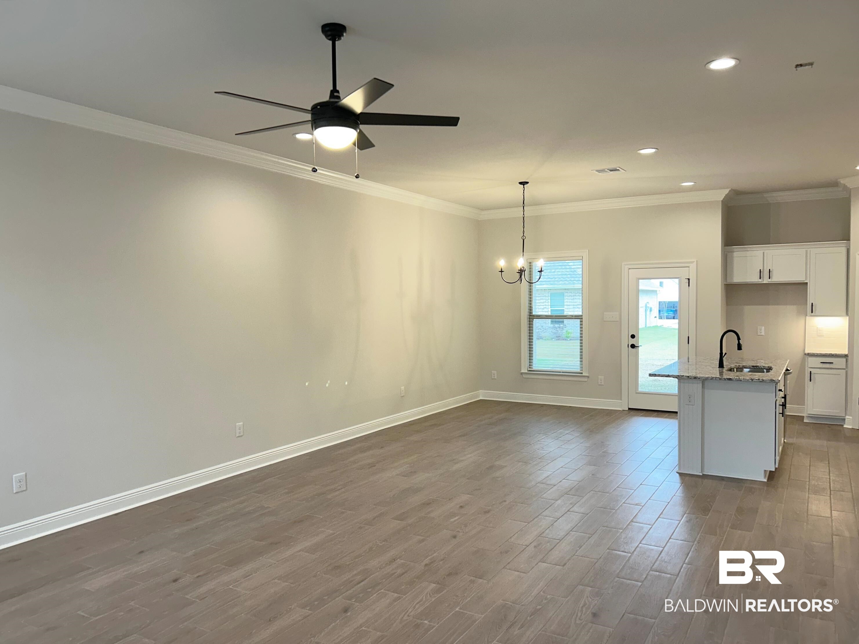 873 Sumter Loop Foley, AL 36535 - Photo 2 of 26 Unfurnished living room with a chandelier, dark wood-type flooring, crown molding, ceiling fan, and recessed lighting