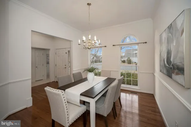 a open kitchen with stainless steel appliances granite countertop a refrigerator a stove a sink a dining table and chairs with wooden floor