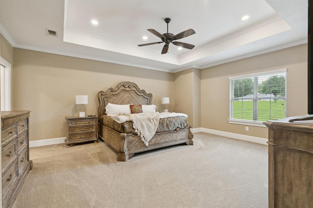 320 Tate Circle Sherman, TX 75090 - Photo 19 of 40 a bedroom with a bed and a chandelier