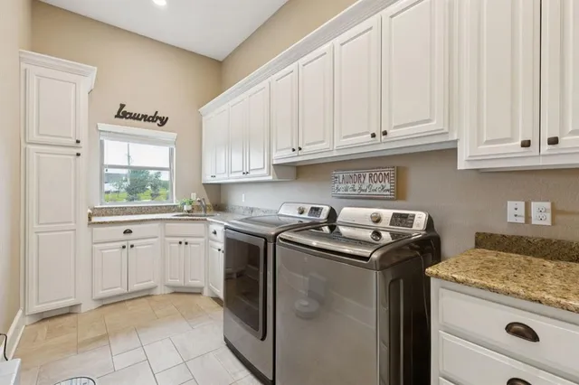 a kitchen with granite countertop cabinets washer and dryer