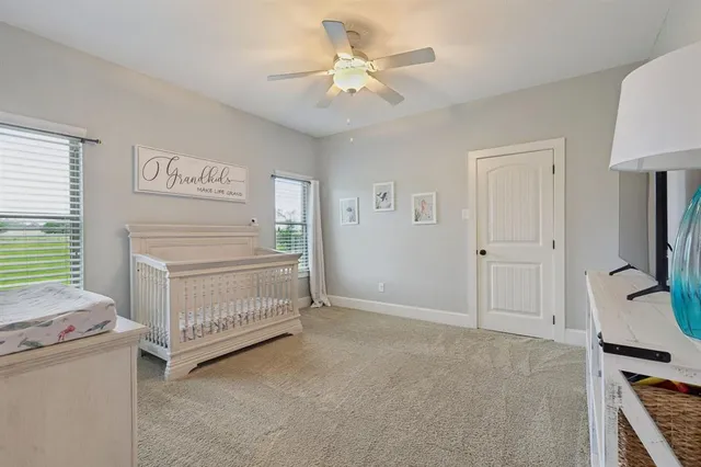 a bedroom with a bed and a flat tv screen on dresser