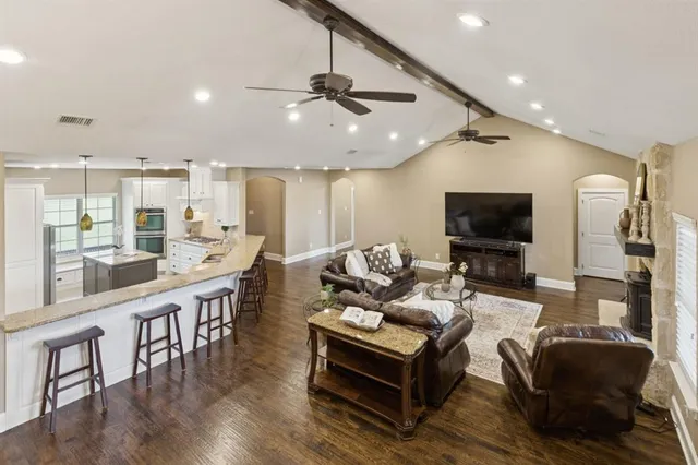 a living room with furniture a flat screen tv and kitchen view