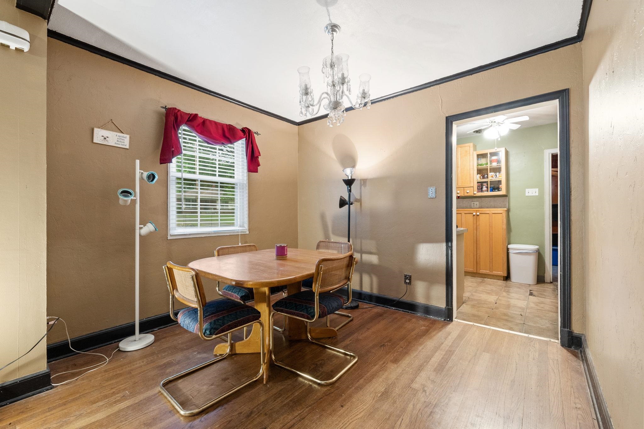 981 Tatum Road Memphis, TN 38122 - Photo 4 of 16 a dining room with wooden floor a chandelier a wooden table and chairs