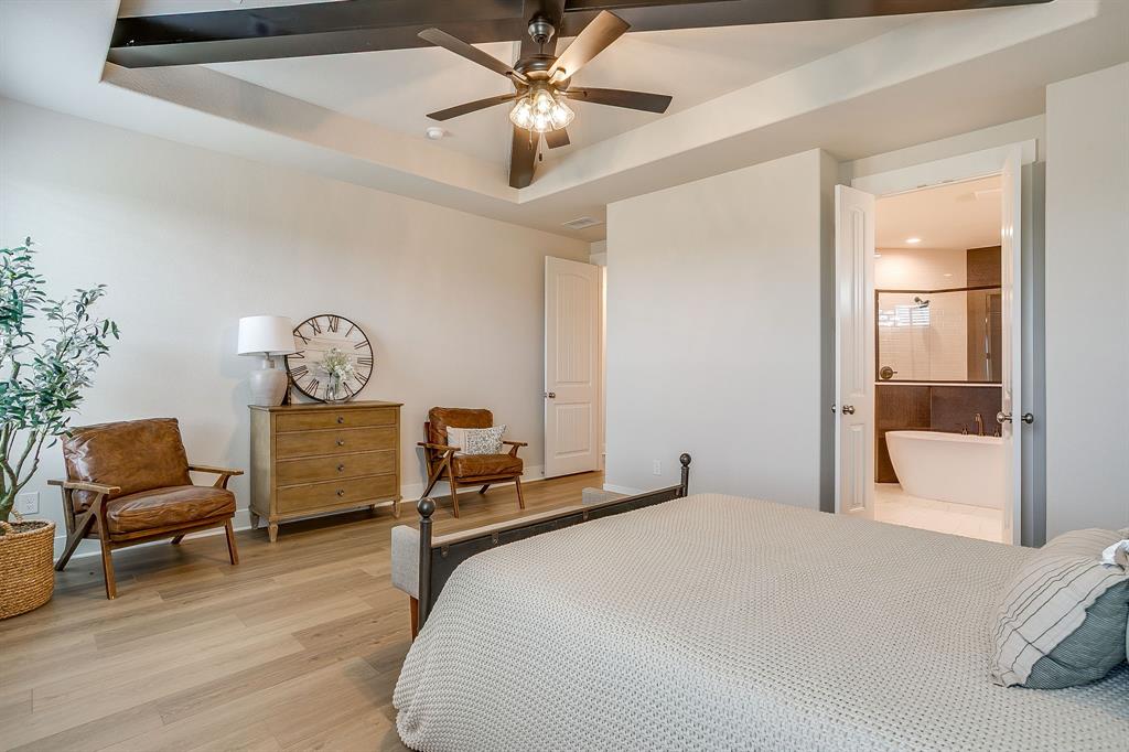 4511 Matador Rnch Road Waxahachie, TX 75165 - Photo 17 of 36 Tray ceiling with exposed beams, wood-finish flooring, and an attached full bathroom featuring a freestanding soaking tub and glass-enclosed shower