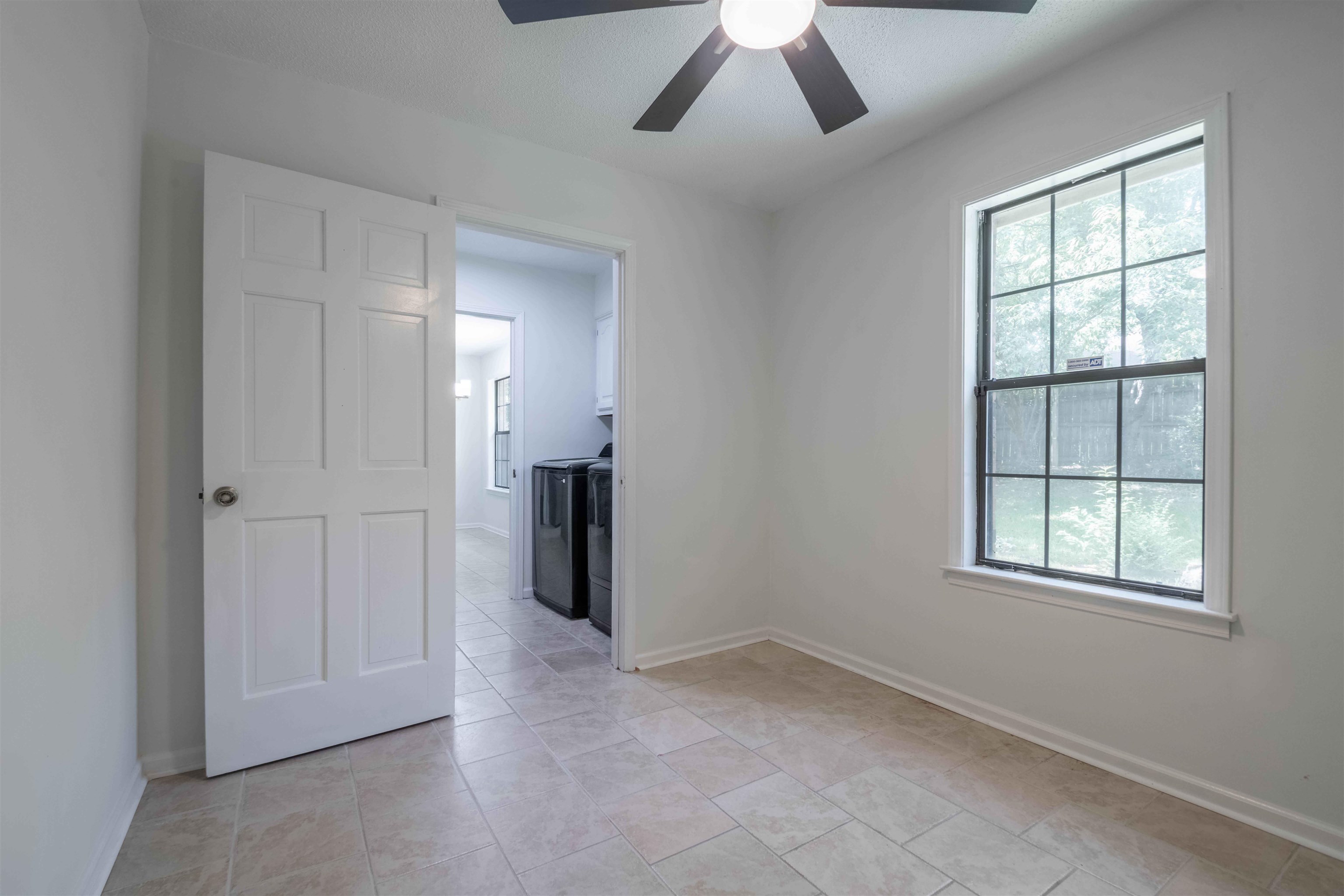 7800 Buck Ridge Cove Memphis, TN 38016 - Photo 20 of 36 Room with light-colored tile flooring, a window offering natural light, and a ceiling fan