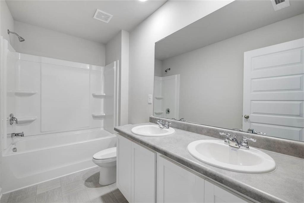 652 Whitman Lane Stockbridge, GA 30281 - Photo 18 of 36 a bathroom with a granite countertop sink toilet and shower