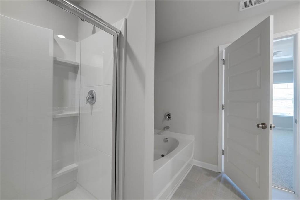 652 Whitman Lane Stockbridge, GA 30281 - Photo 10 of 36 a bathroom with a bathtub and a shower