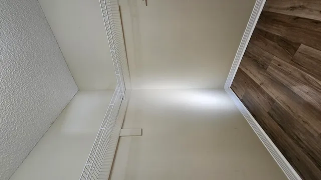 an empty room with a ceiling fan and a window