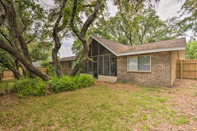a view of a house with a yard and large tree