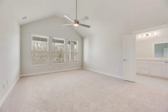 en empty room with windows and ceiling fan