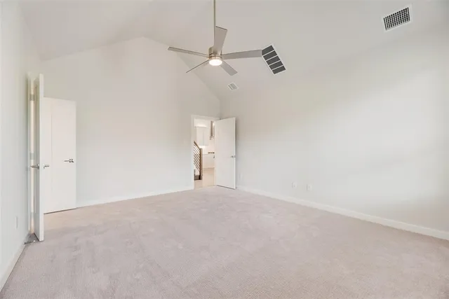 an empty room with a ceiling fan and a window