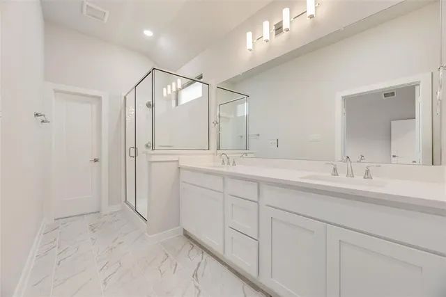 a bathroom with double sink and a mirror