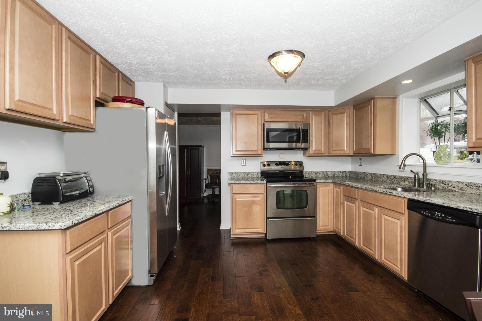 9336 Ramblebrook Road Baltimore, MD 21236 - Photo 4 of 30 a kitchen with granite countertop stainless steel appliances and wooden cabinets
