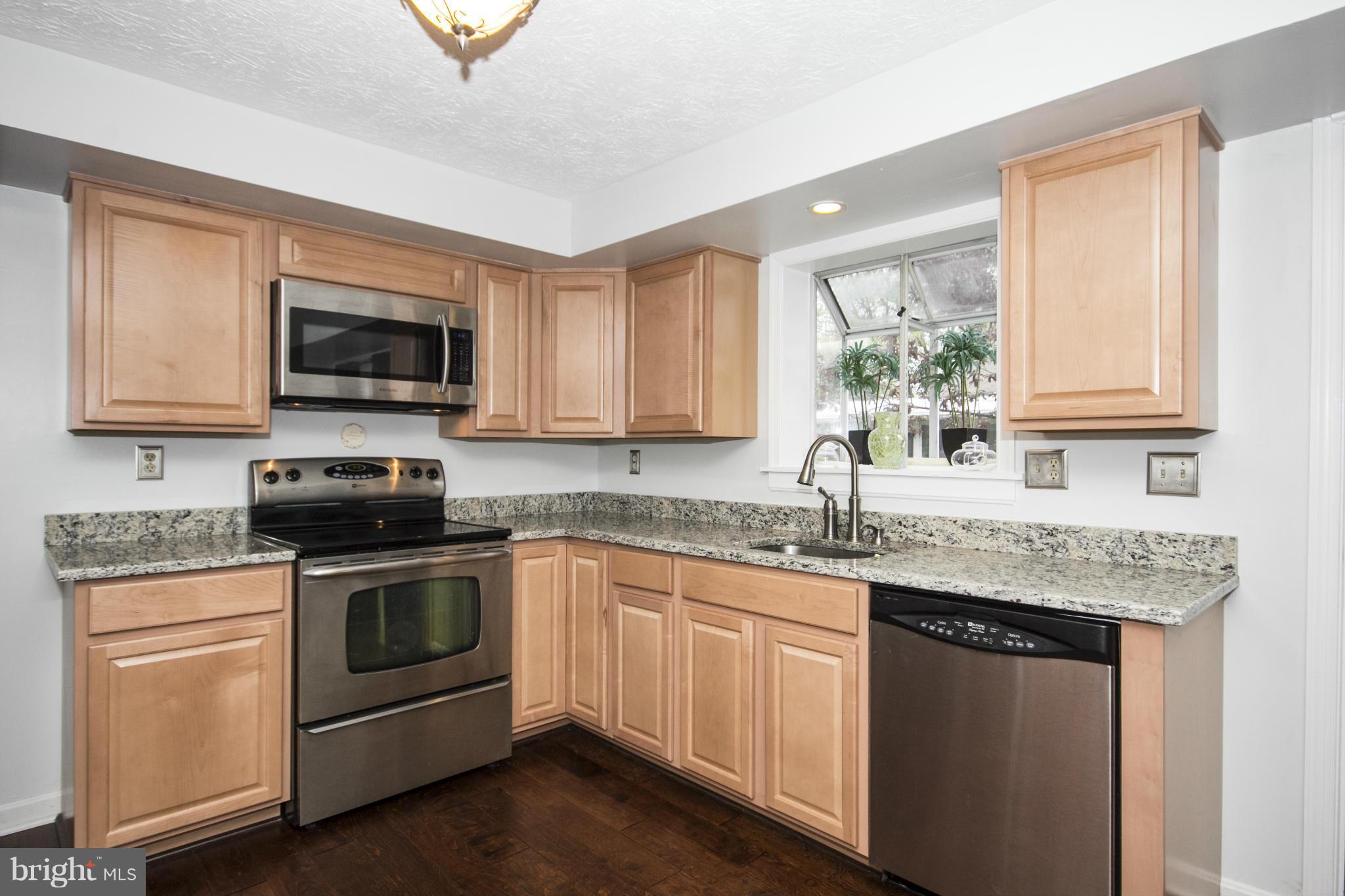 9336 Ramblebrook Road Baltimore, MD 21236 - Photo 6 of 30 a kitchen with granite countertop a sink and a stove top oven