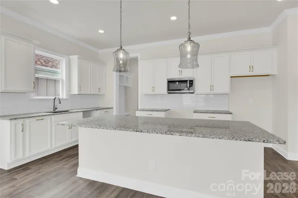 a large kitchen with granite countertop white cabinets and a granite counter tops