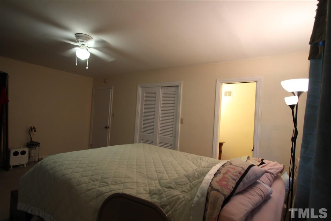 1414 West Garner Road Garner, NC 27529 - Photo 14 of 16 a bedroom with a bed and a chandelier