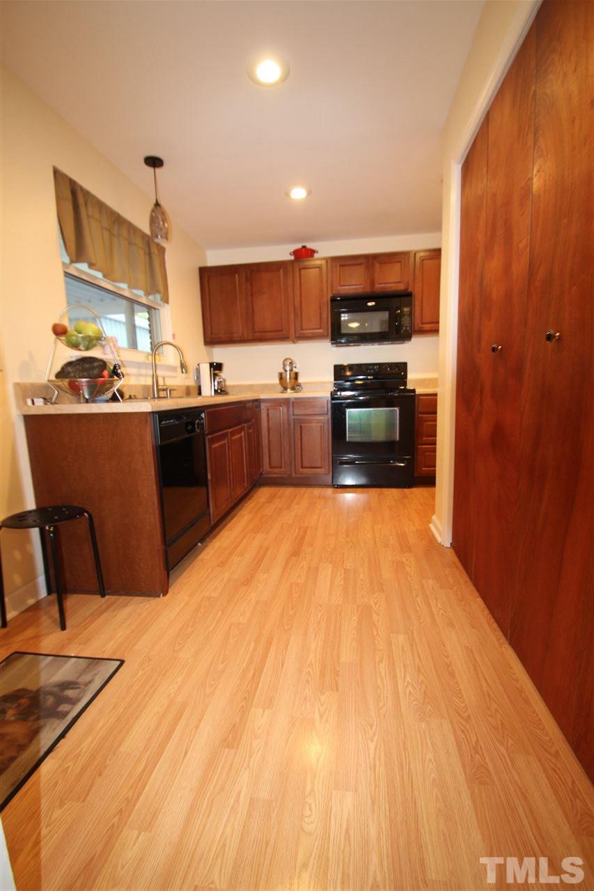 1414 West Garner Road Garner, NC 27529 - Photo 8 of 16 a kitchen with stainless steel appliances wooden floor and large window