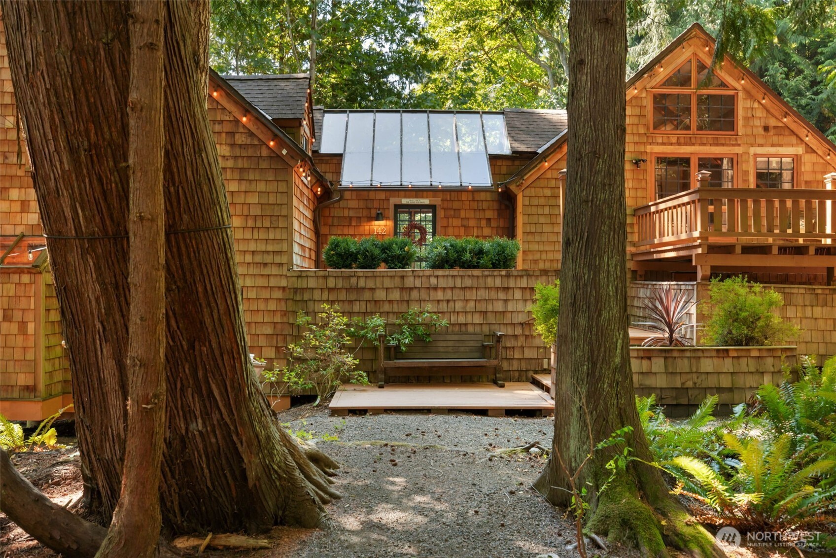 a view of a brick house with a small yard and wooden fence