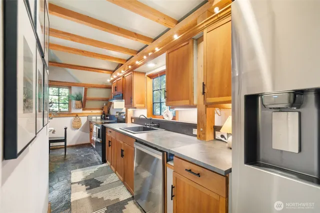 a large kitchen with a large window and stainless steel appliances