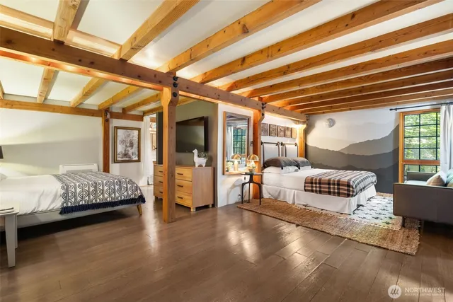 a bedroom with a bed and large windows