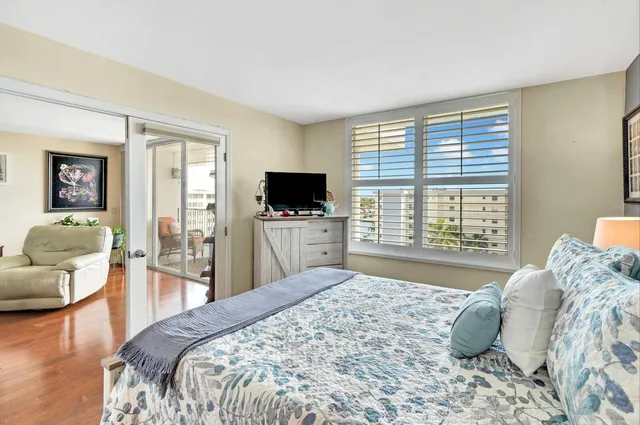 a bedroom with a large bed and a flat tv screen next to a window