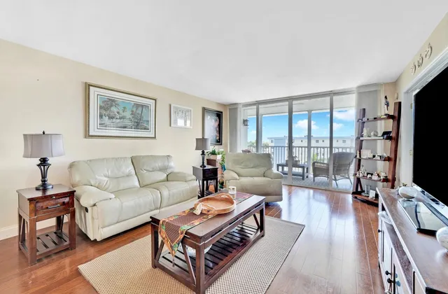 a living room with furniture a flat screen tv and a large window