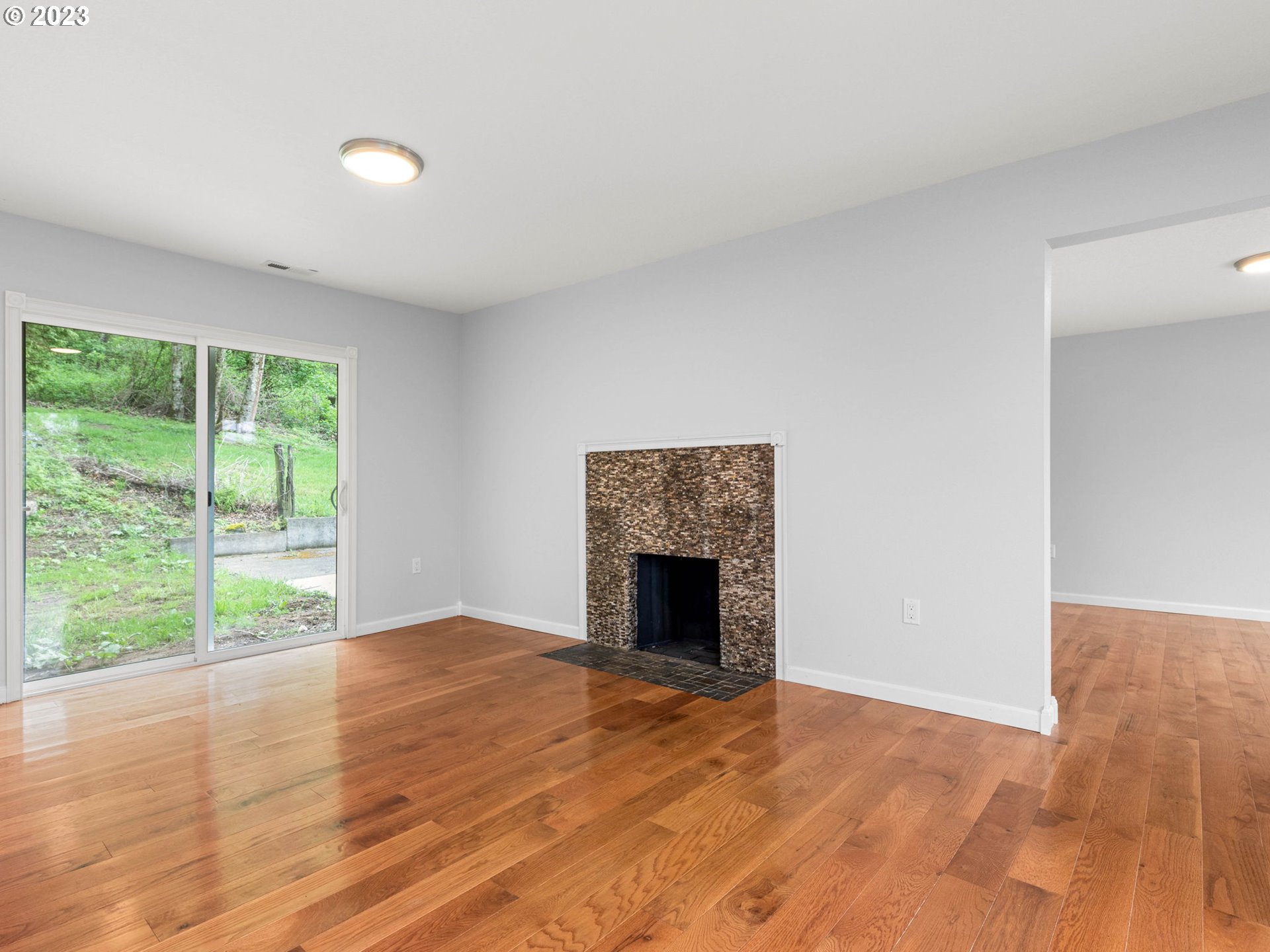 36810 Northeast Reed Road Corbett, OR 97019 - Photo 14 of 28 a view of empty room with wooden floor and fireplace