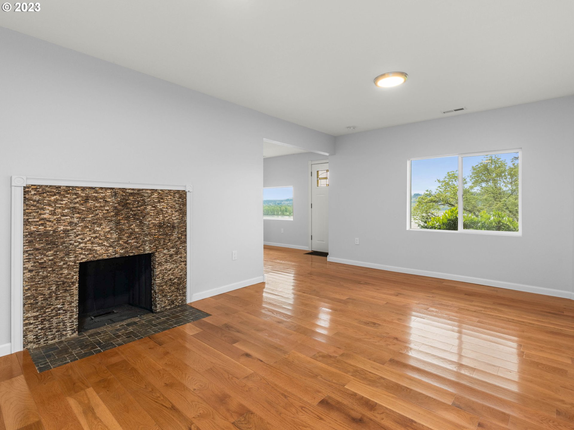 36810 Northeast Reed Road Corbett, OR 97019 - Photo 19 of 28 a view of an empty room with wooden floor and a fireplace