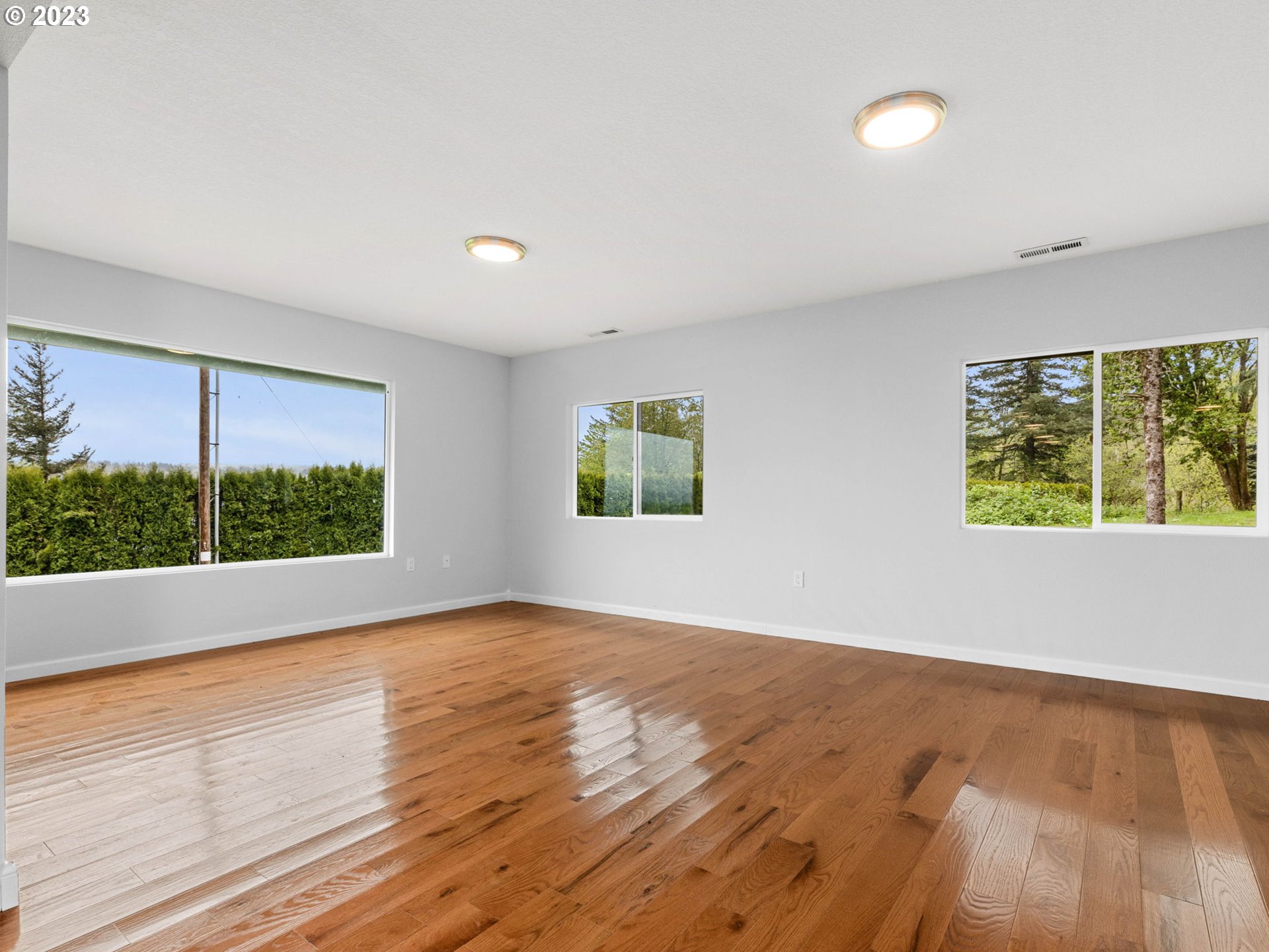 36810 Northeast Reed Road Corbett, OR 97019 - Photo 7 of 28 an empty room with wooden floor and windows