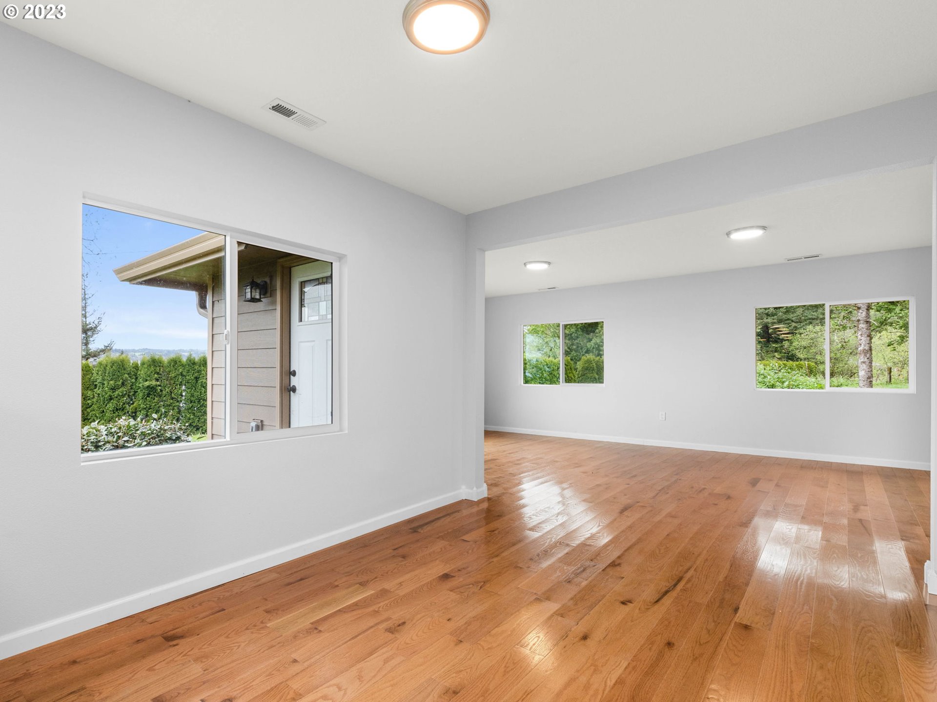 36810 Northeast Reed Road Corbett, OR 97019 - Photo 9 of 28 an empty room with wooden floor and windows