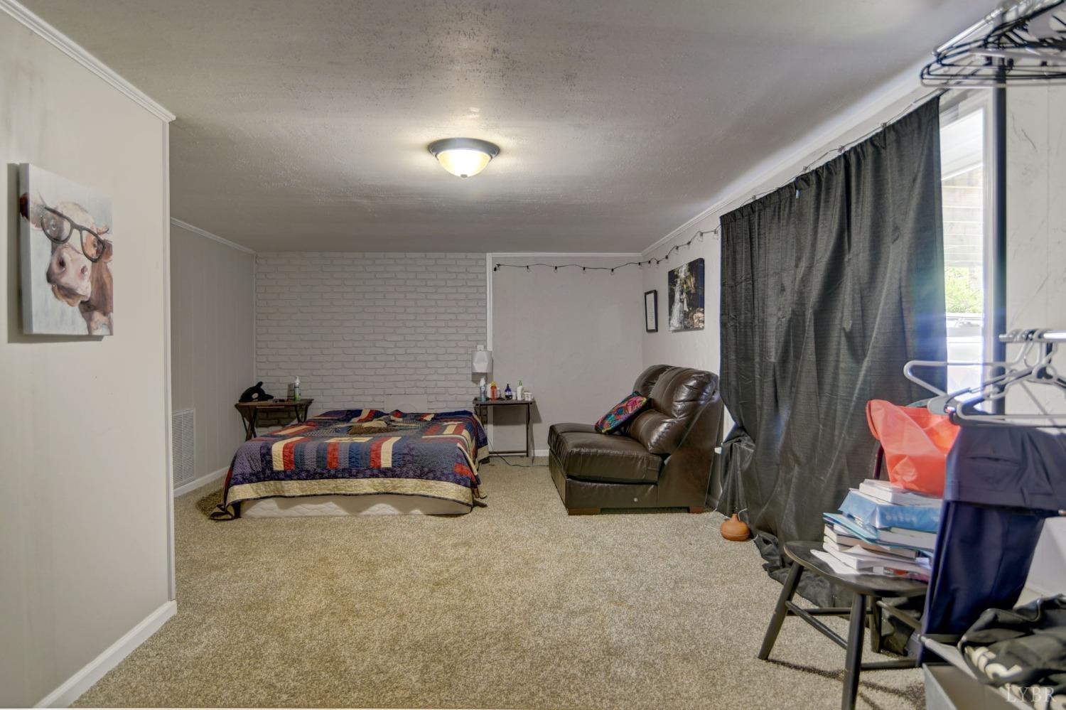 1112 Twinleaf Road Goode, VA 24556 - Photo 13 of 36 a living room with furniture a large window and a flat screen tv
