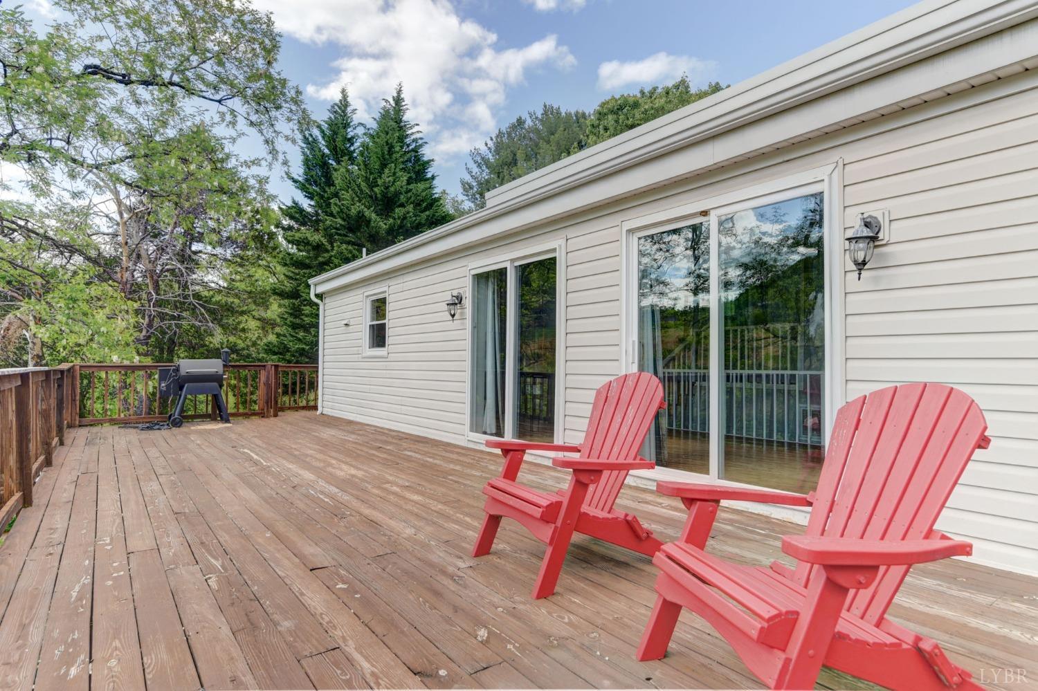 1112 Twinleaf Road Goode, VA 24556 - Photo 20 of 36 a backyard of a house with wooden floor table and chairs