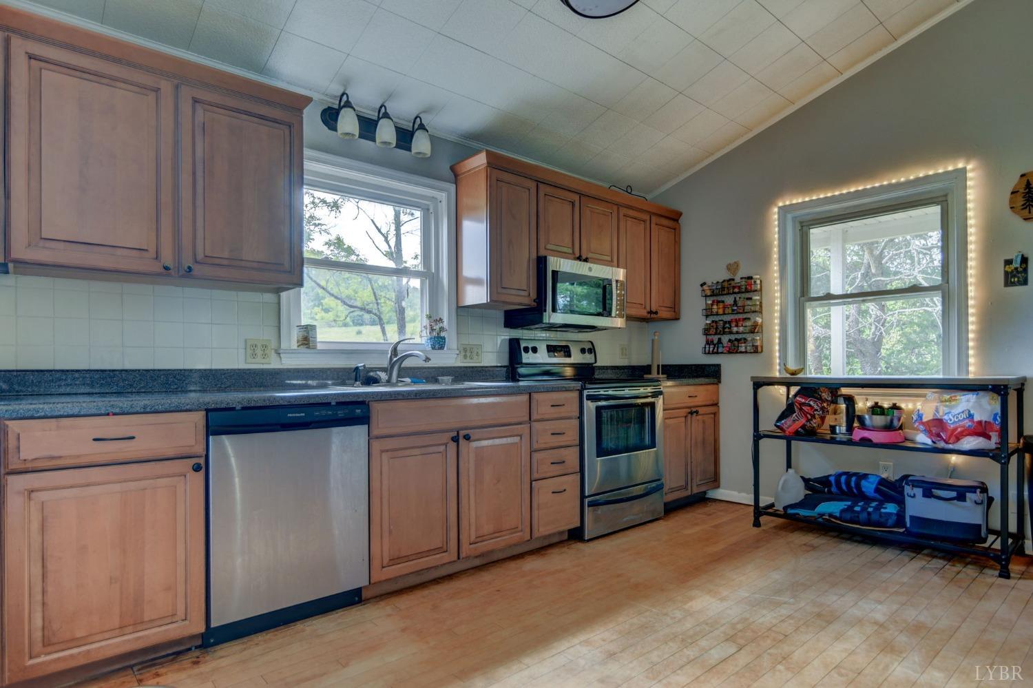 1112 Twinleaf Road Goode, VA 24556 - Photo 3 of 36 a kitchen with stainless steel appliances granite countertop a stove a sink and a microwave