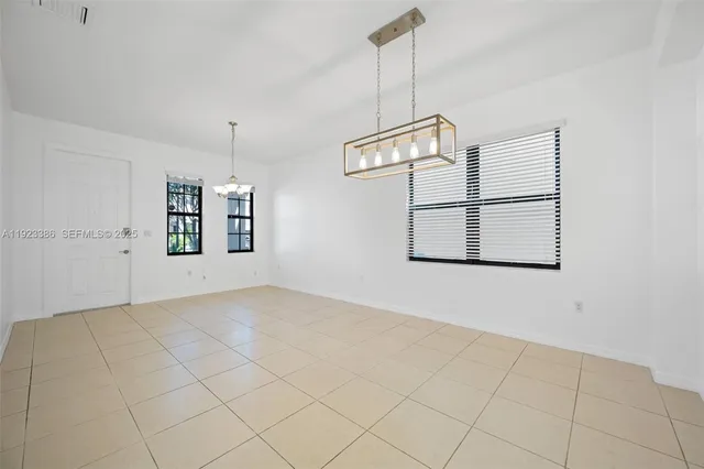 a view of a chandelier fan and refrigerator