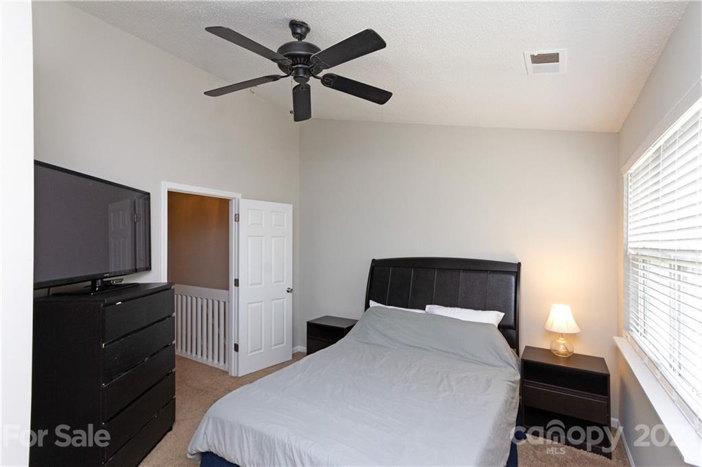 8246 Rudolph Road Charlotte, NC 28216 - Photo 23 of 29 a bedroom with a bed and a flat tv screen on the dresser