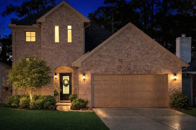 a view of a brick house with many windows and plants