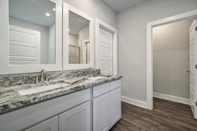 a bathroom with a granite countertop sink and a mirror
