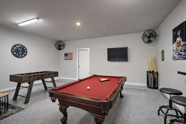 a room with furniture pool table and a flat screen tv