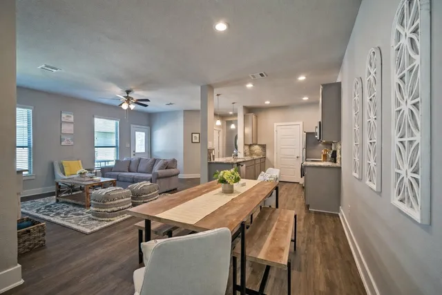 a living room with stainless steel appliances furniture stove and a table