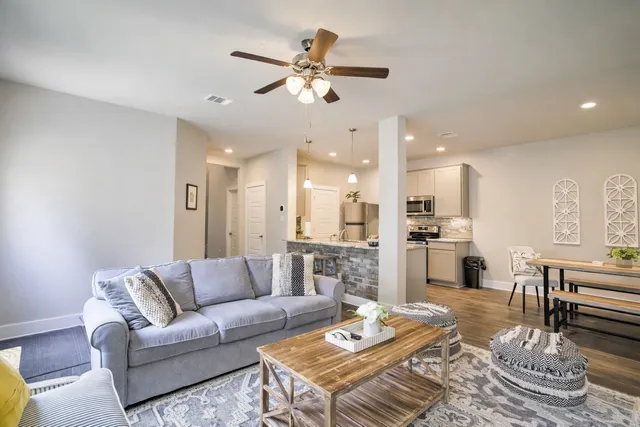 a living room with furniture kitchen view and a table